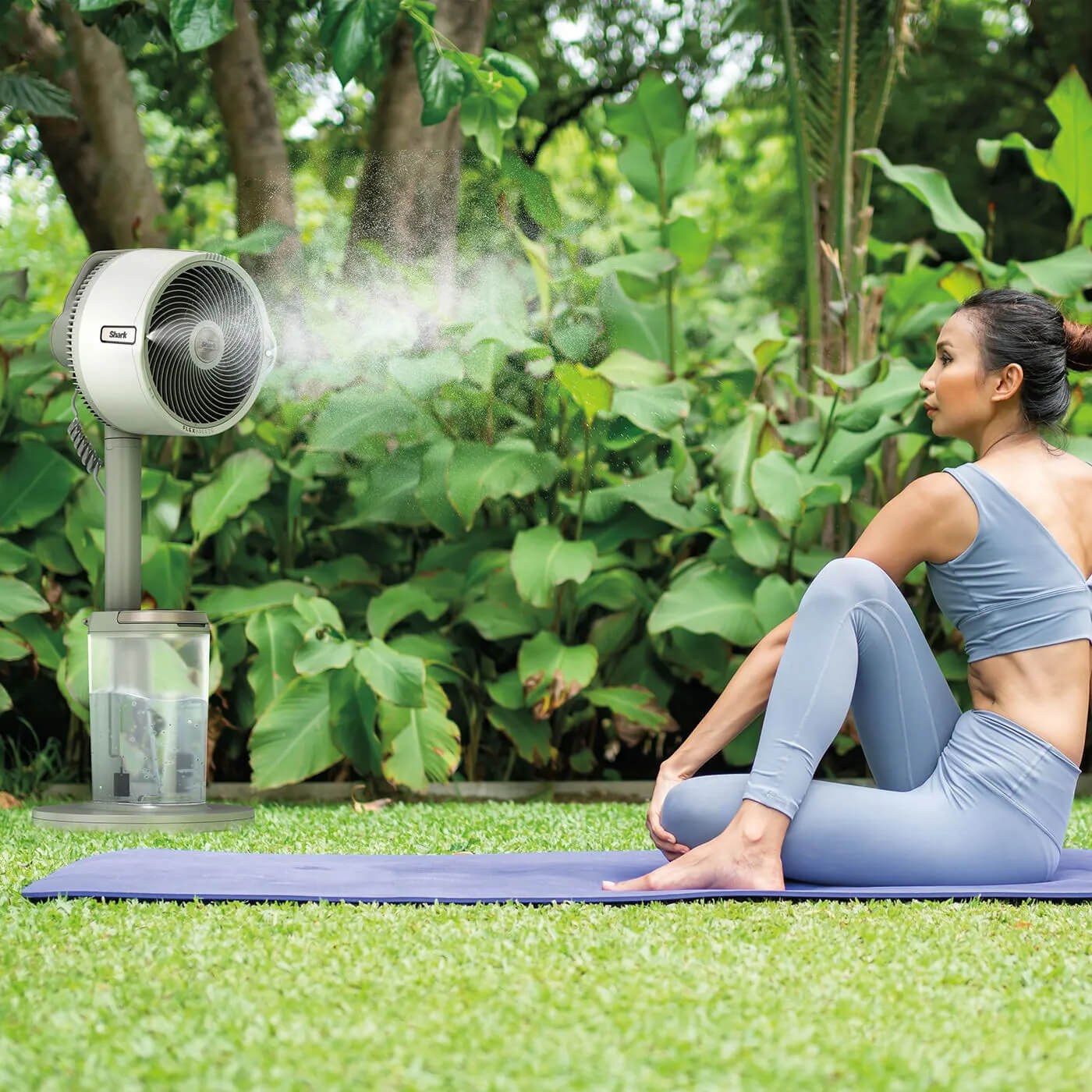 Image of Women sat outside on a yoga mat with the Shark FlexBreeze fan